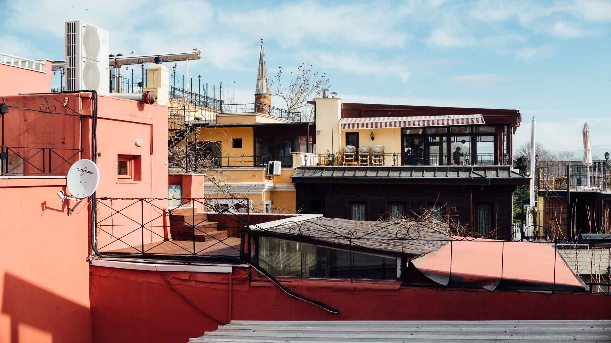 A salmon pink building and other rooftops in Istanbul, Turkey. Travel photography by Paige Gribb