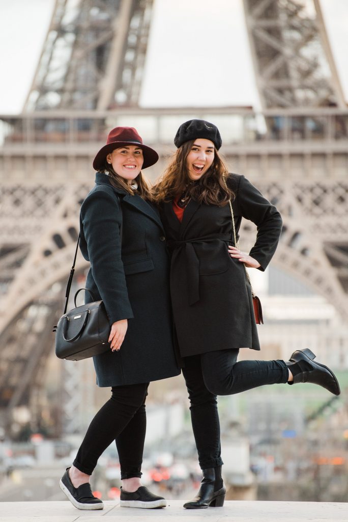 two women in coats and hats during an eiffel tower photo shoot in paris, france