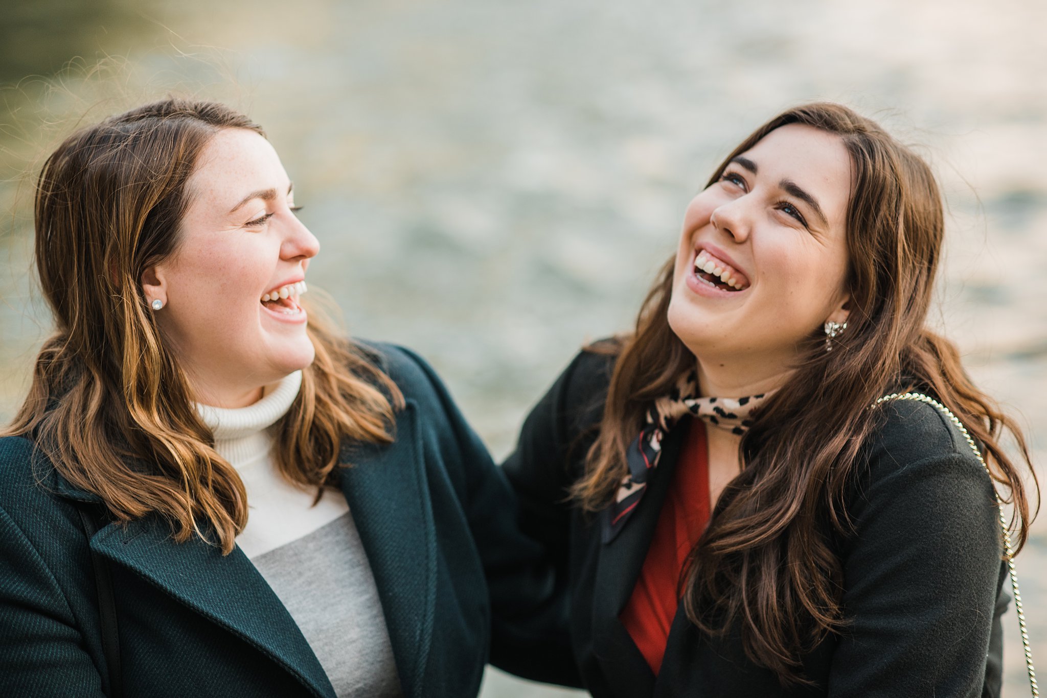 Portrait of two sisters laughing together during a professional photo shoot in Paris