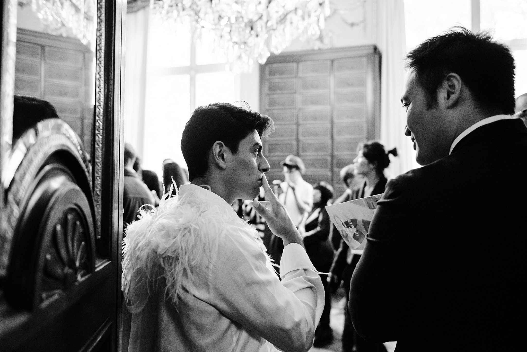 two men look in on the backstage area, flying solo nyc fashion show at paris fashion week